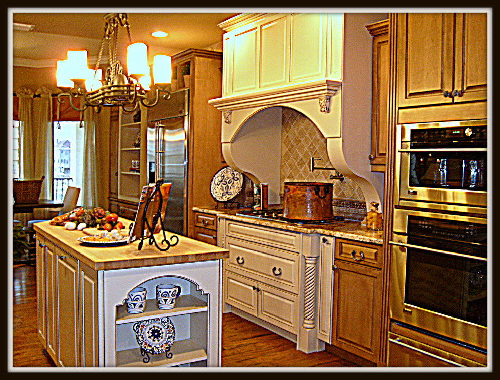 Inspiration for a large traditional galley kitchen/diner in Tampa with stainless steel appliances, medium hardwood flooring and an island.