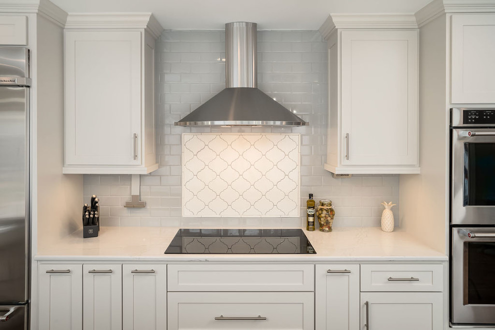 Inspiration for a large traditional l-shaped kitchen in Columbus with a submerged sink, shaker cabinets, white cabinets, engineered stone countertops, grey splashback, ceramic splashback, stainless steel appliances, dark hardwood flooring, an island, brown floors and grey worktops.