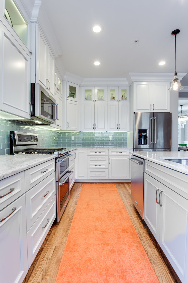 Inspiration for a medium sized classic l-shaped kitchen in Baltimore with a submerged sink, recessed-panel cabinets, white cabinets, engineered stone countertops, green splashback, metro tiled splashback, stainless steel appliances, medium hardwood flooring and an island.