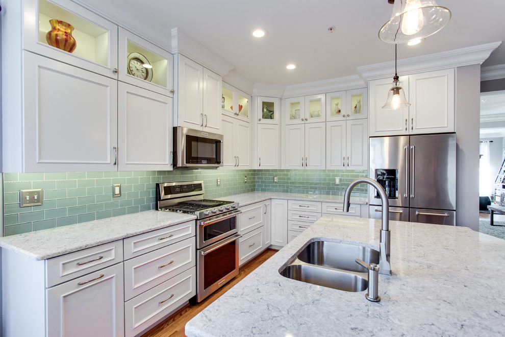 Design ideas for a medium sized classic l-shaped kitchen in Baltimore with a submerged sink, recessed-panel cabinets, white cabinets, engineered stone countertops, green splashback, metro tiled splashback, stainless steel appliances, medium hardwood flooring and an island.