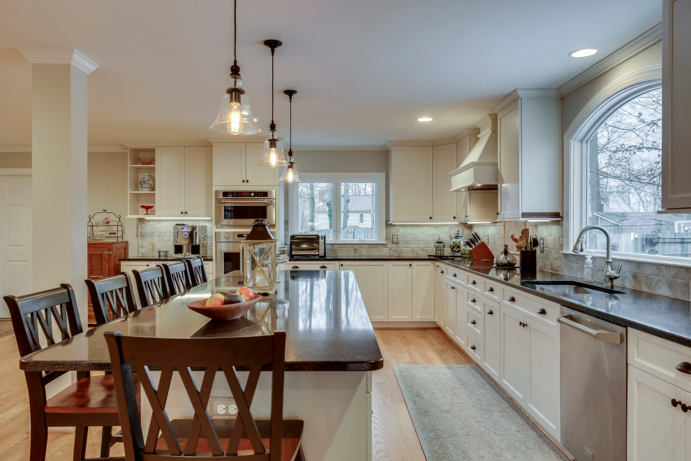 Photo of a large traditional l-shaped kitchen in DC Metro with a submerged sink, recessed-panel cabinets, engineered stone countertops, stainless steel appliances and an island.