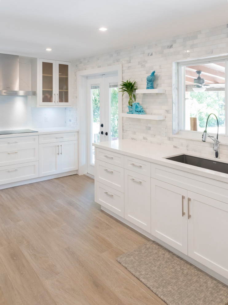 Design ideas for a medium sized classic galley kitchen pantry in Miami with a submerged sink, shaker cabinets, white cabinets, engineered stone countertops, white splashback, marble splashback, stainless steel appliances, light hardwood flooring and white worktops.