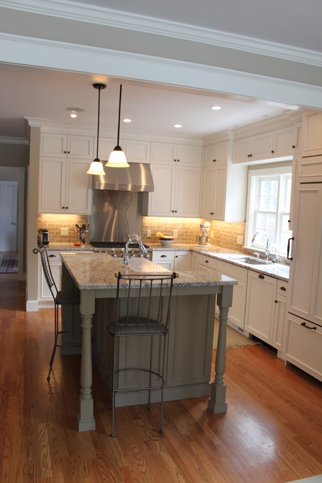 Eat-in kitchen - mid-sized transitional u-shaped medium tone wood floor eat-in kitchen idea in Boston with an undermount sink, recessed-panel cabinets, white cabinets, granite countertops, beige backsplash, ceramic backsplash, paneled appliances and an island