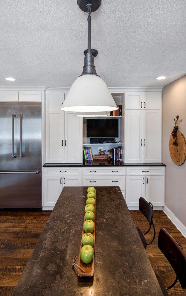 Kitchen - country l-shaped dark wood floor kitchen idea in Minneapolis with a farmhouse sink, shaker cabinets, white cabinets, white backsplash, subway tile backsplash, stainless steel appliances and an island