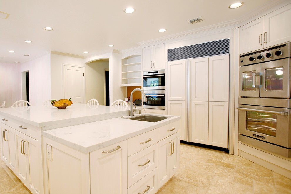 Immagine di una cucina chic di medie dimensioni con lavello sottopiano, ante con riquadro incassato, ante bianche, top in marmo e elettrodomestici in acciaio inossidabile