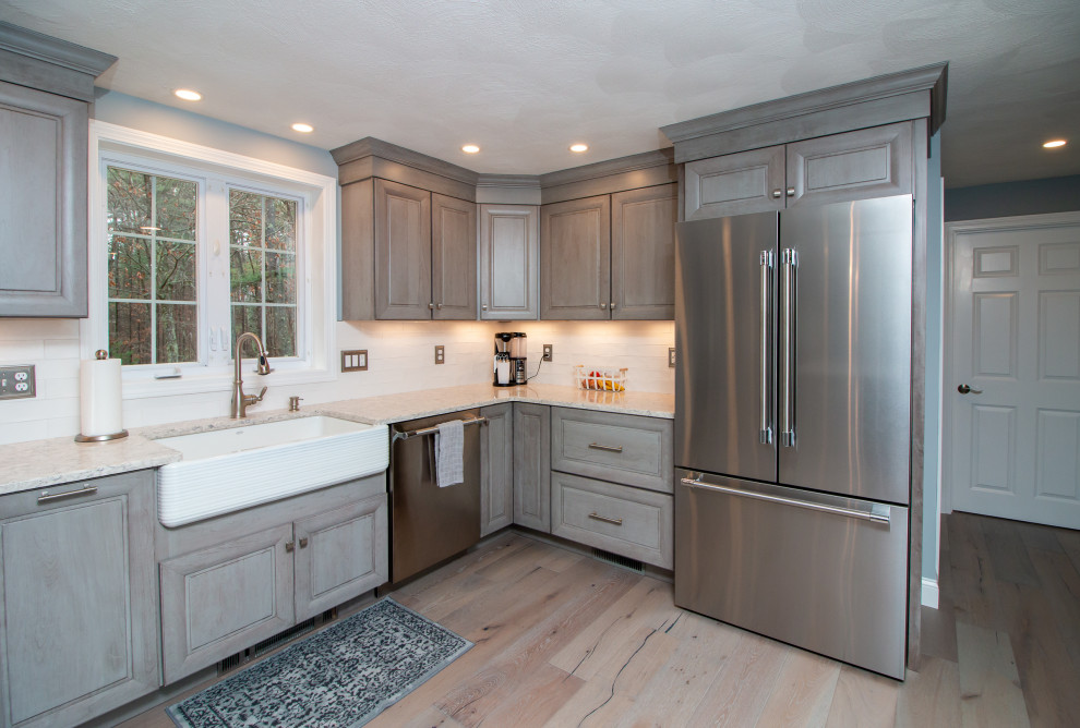 Large transitional l-shaped vinyl floor and multicolored floor eat-in kitchen photo in Boston with a farmhouse sink, raised-panel cabinets, gray cabinets, quartz countertops, white backsplash, ceramic backsplash, stainless steel appliances, an island and multicolored countertops
