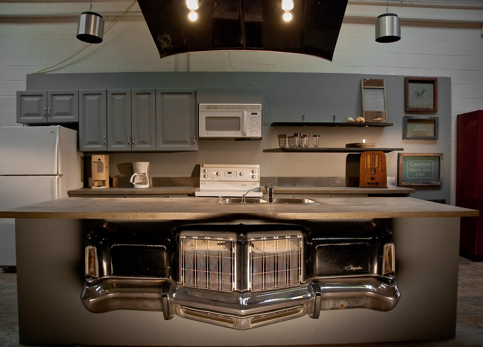 На фото: параллельная кухня в стиле лофт с накладной мойкой, фасадами с выступающей филенкой, серыми фасадами, столешницей из бетона и белой техникой