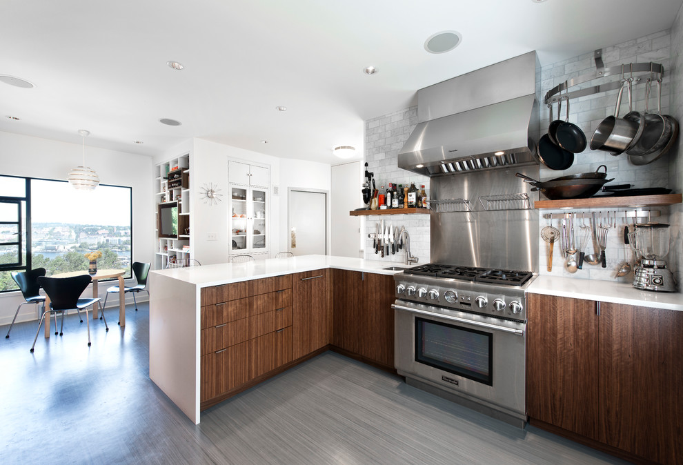 Moderne Wohnküche mit flächenbündigen Schrankfronten, dunklen Holzschränken, Küchenrückwand in Weiß, Rückwand aus Steinfliesen und Küchengeräten aus Edelstahl in Seattle