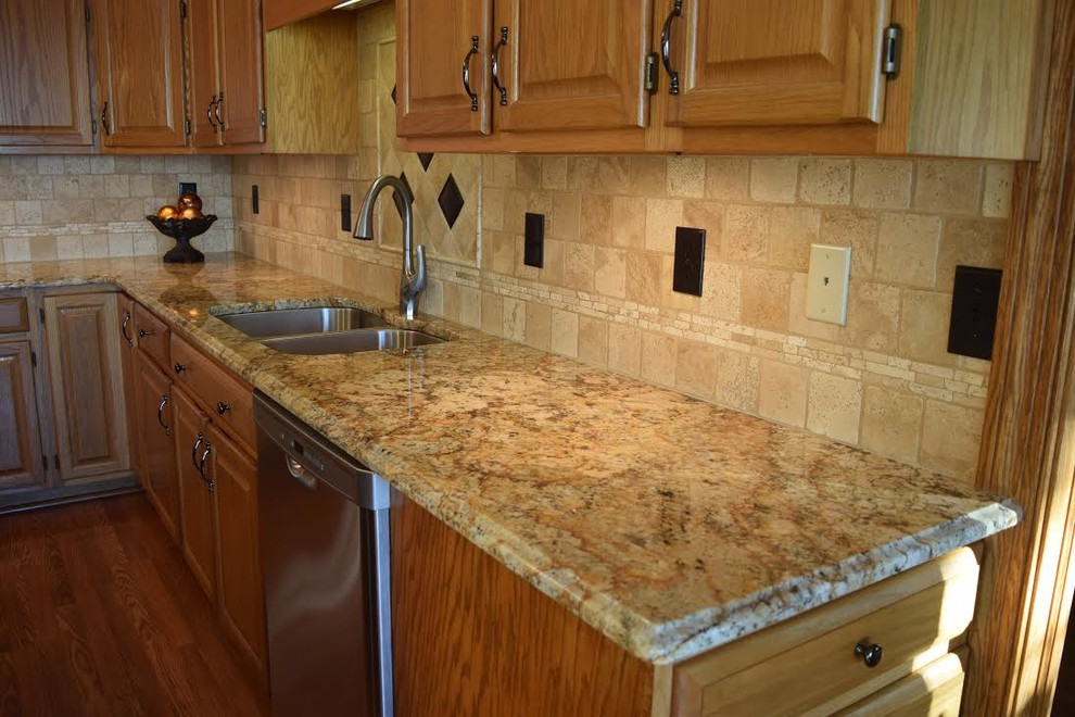 Exempel på ett mellanstort rustikt kök, med en undermonterad diskho, luckor med upphöjd panel, skåp i mellenmörkt trä, granitbänkskiva, beige stänkskydd, stänkskydd i travertin, rostfria vitvaror, klinkergolv i porslin, en köksö och brunt golv