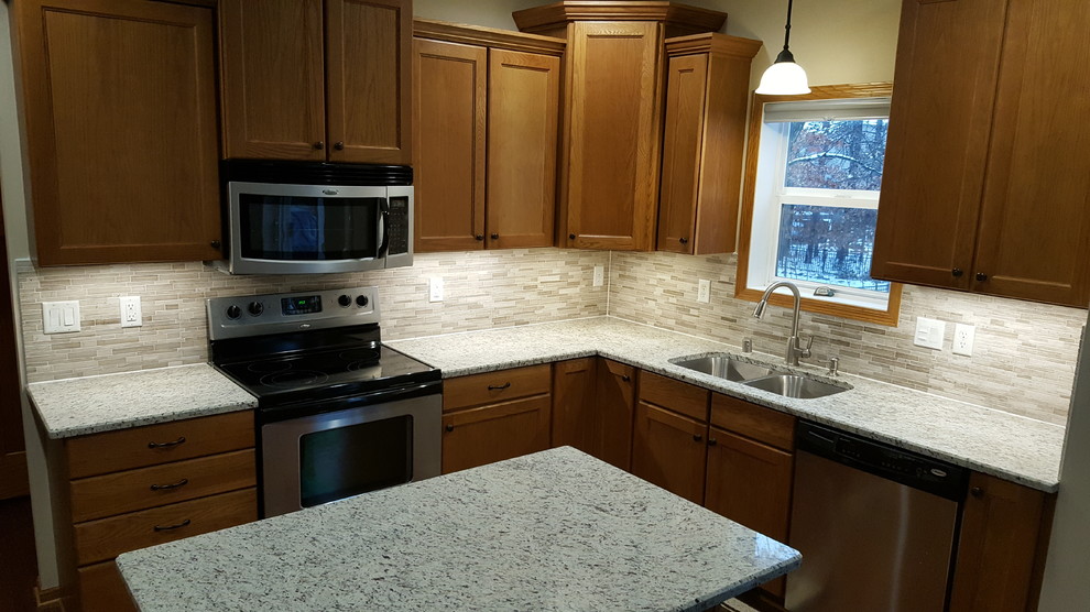 Mid-sized island style l-shaped kitchen pantry photo in Minneapolis with brown backsplash, travertine backsplash, stainless steel appliances and an island