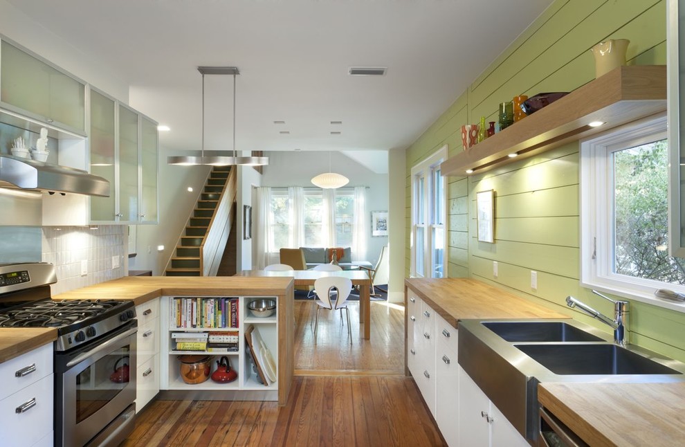 Example of a mountain style kitchen design in Austin with a double-bowl sink, wood countertops, flat-panel cabinets, white cabinets and stainless steel appliances