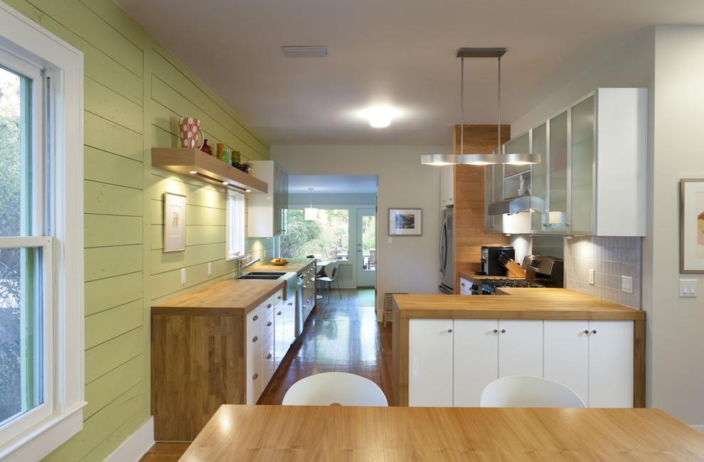 Imagen de cocina moderna con encimera de madera, armarios tipo vitrina y puertas de armario blancas