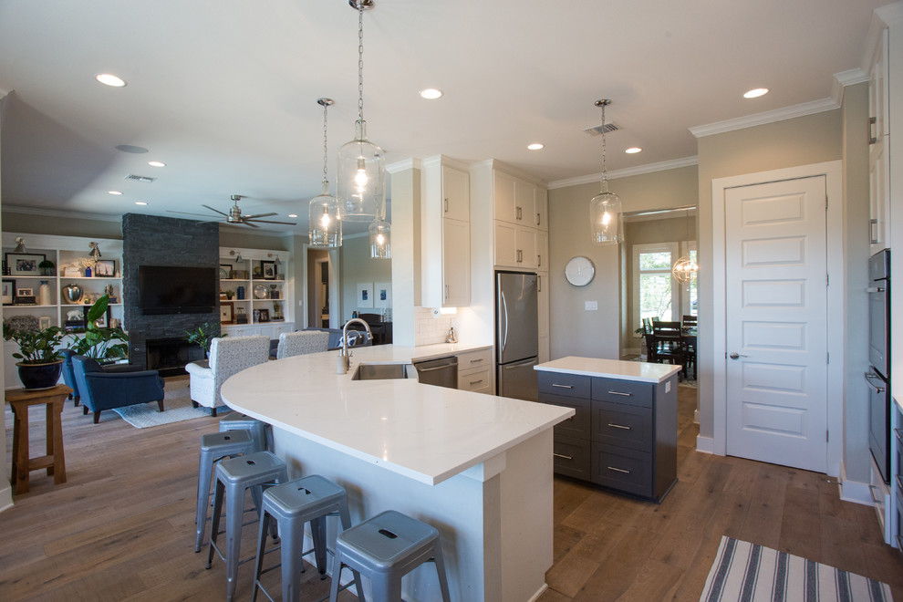 Example of a large transitional light wood floor and beige floor eat-in kitchen design in Austin with a farmhouse sink, shaker cabinets, white cabinets, quartz countertops, white backsplash, subway tile backsplash, stainless steel appliances and an island