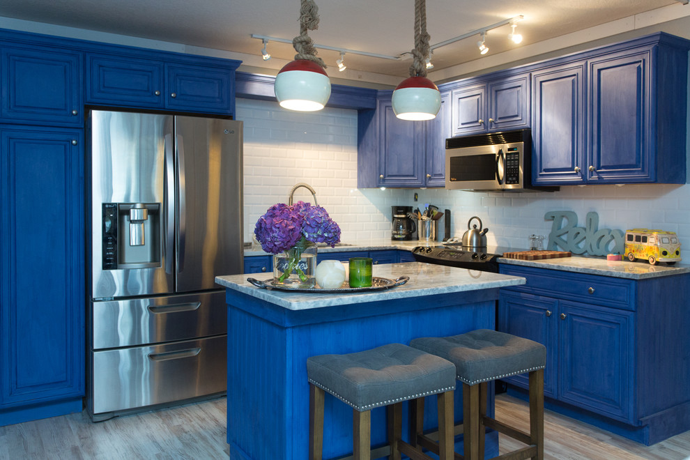 Mid-sized beach style l-shaped kitchen photo in Tampa with raised-panel cabinets, blue cabinets, marble countertops, white backsplash, stainless steel appliances, an island and subway tile backsplash