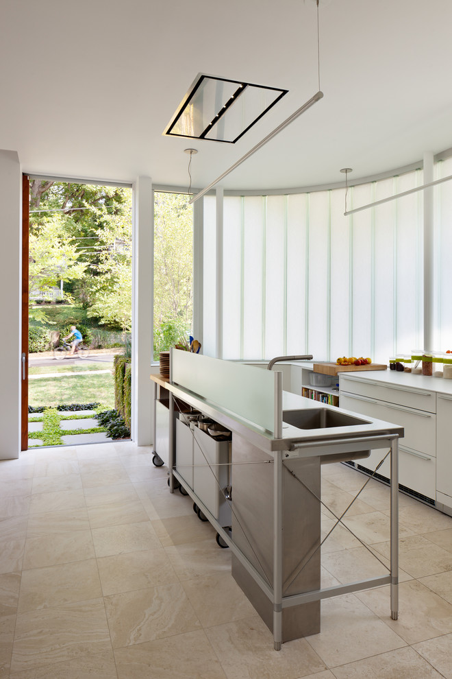 Inspiration for a medium sized contemporary galley kitchen in DC Metro with an integrated sink, flat-panel cabinets, white cabinets, laminate countertops, stainless steel appliances, travertine flooring and an island.