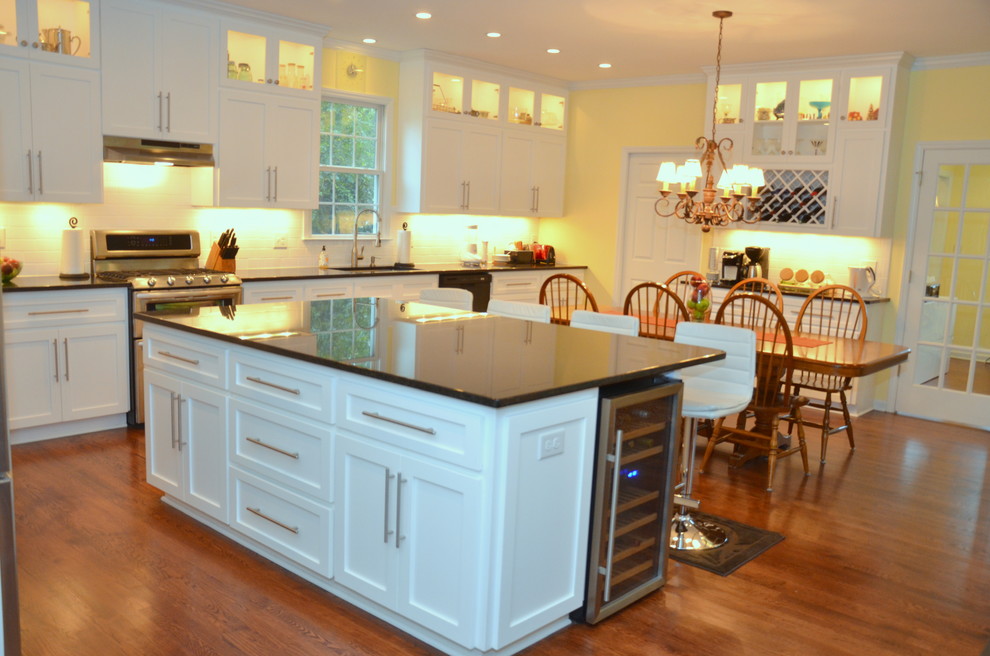 Inspiration for a timeless eat-in kitchen remodel in Raleigh with an undermount sink, shaker cabinets, white cabinets, granite countertops, white backsplash, subway tile backsplash and stainless steel appliances