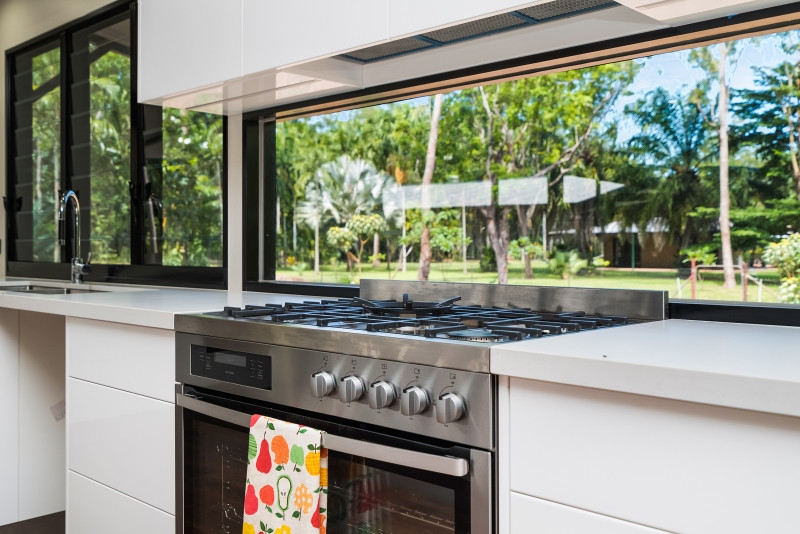 Cette photo montre une cuisine exotique avec un électroménager en acier inoxydable, un sol en vinyl et îlot.