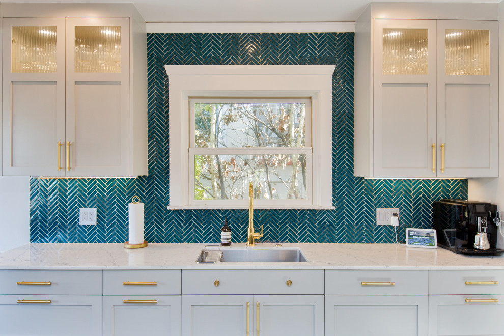 Photo of a medium sized classic galley kitchen/diner in San Francisco with a submerged sink, shaker cabinets, grey cabinets, engineered stone countertops, green splashback, glass tiled splashback, stainless steel appliances, porcelain flooring, an island, grey floors and white worktops.