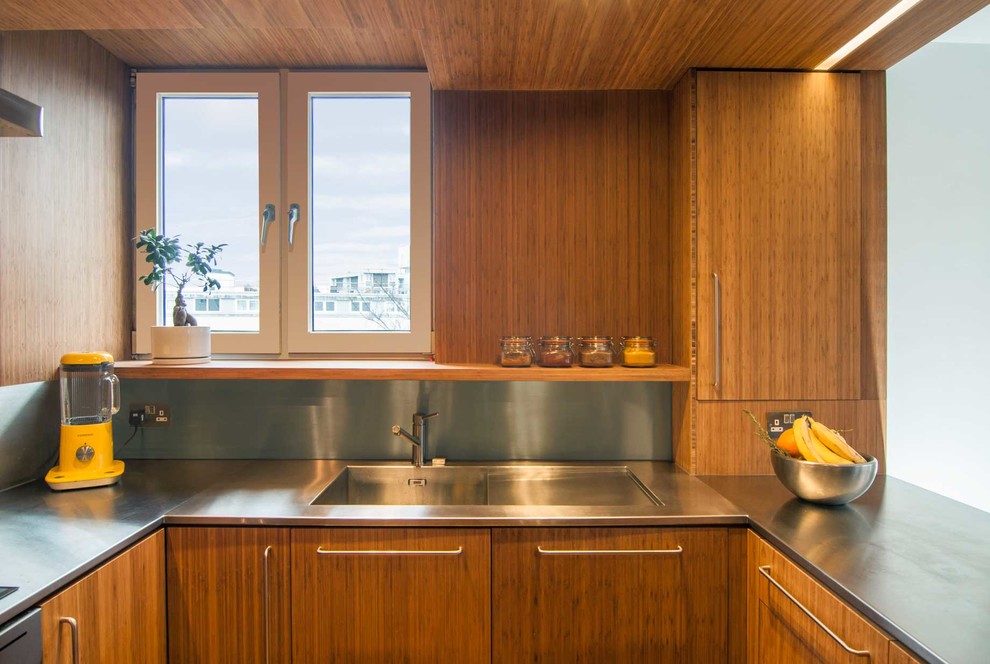 Aménagement d'une petite cuisine américaine contemporaine en U avec un évier posé, un plan de travail en inox, une crédence grise et parquet en bambou.