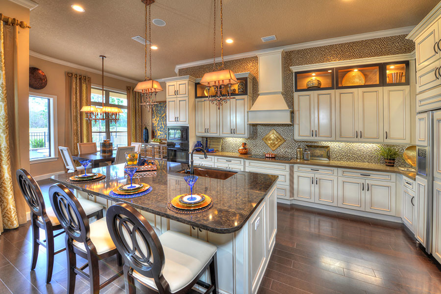 Open concept kitchen - large transitional l-shaped medium tone wood floor open concept kitchen idea in Orlando with a single-bowl sink, recessed-panel cabinets, white cabinets, marble countertops, multicolored backsplash, glass tile backsplash, black appliances and an island