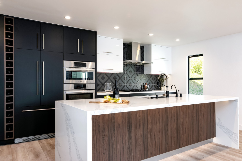 ロサンゼルスにある高級な中くらいなコンテンポラリースタイルのおしゃれなキッチン (シングルシンク、フラットパネル扉のキャビネット、黒いキャビネット、クオーツストーンカウンター、黒いキッチンパネル、セラミックタイルのキッチンパネル、パネルと同色の調理設備、クッションフロア、ベージュの床、白いキッチンカウンター) の写真