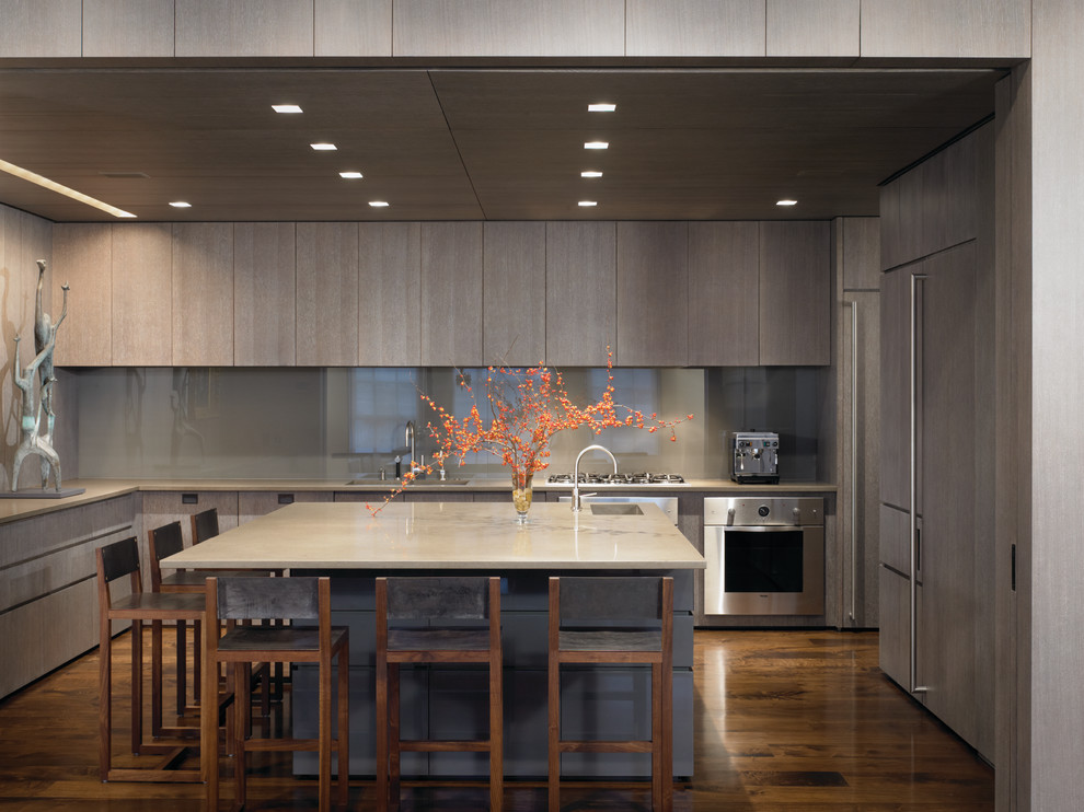 Example of a minimalist u-shaped kitchen design in Chicago with flat-panel cabinets, gray cabinets, gray backsplash, glass sheet backsplash and paneled appliances