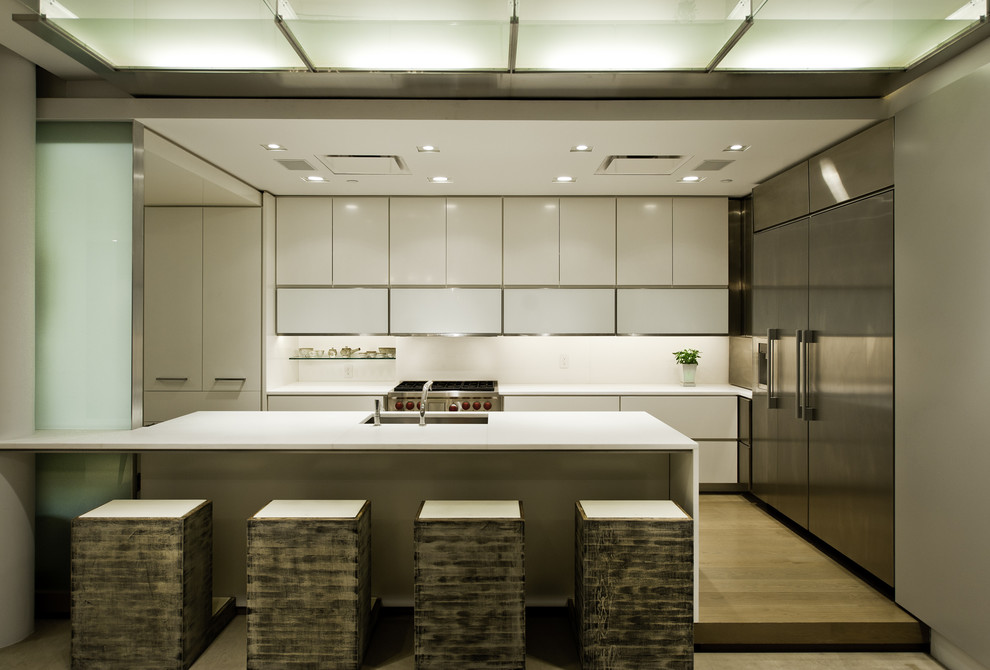 Ejemplo de cocina contemporánea con electrodomésticos de acero inoxidable y barras de cocina