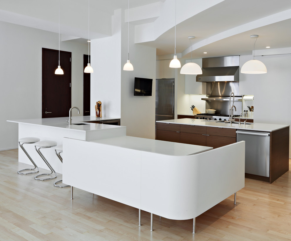 Modern inredning av ett stort kök, med en undermonterad diskho, släta luckor, vita skåp, granitbänkskiva, vitt stänkskydd, stänkskydd i metallkakel, rostfria vitvaror, ljust trägolv och en köksö