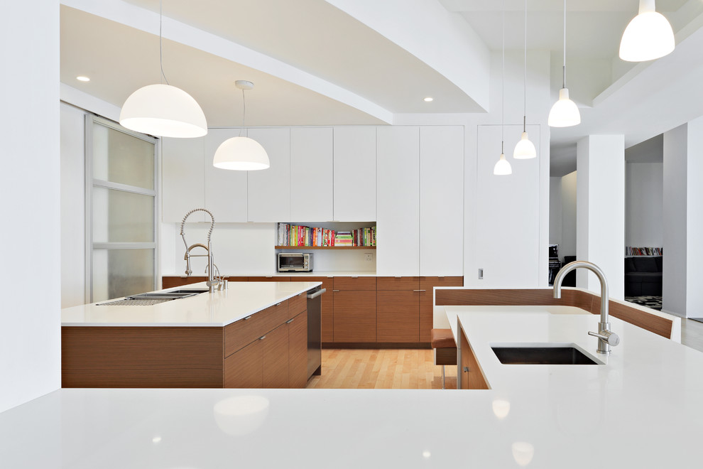 Inspiration for a large modern u-shaped light wood floor eat-in kitchen remodel in New York with an undermount sink, flat-panel cabinets, white cabinets, solid surface countertops, metallic backsplash, metal backsplash, stainless steel appliances and an island