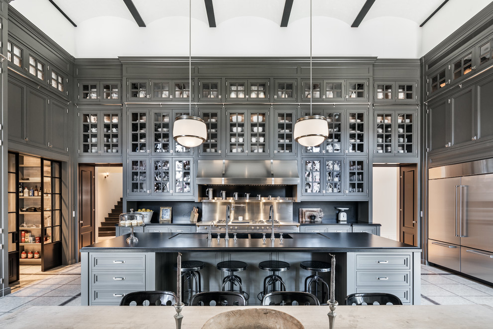 Eat-in kitchen - transitional u-shaped gray floor eat-in kitchen idea in New York with glass-front cabinets, gray cabinets, stainless steel appliances, an island and black countertops