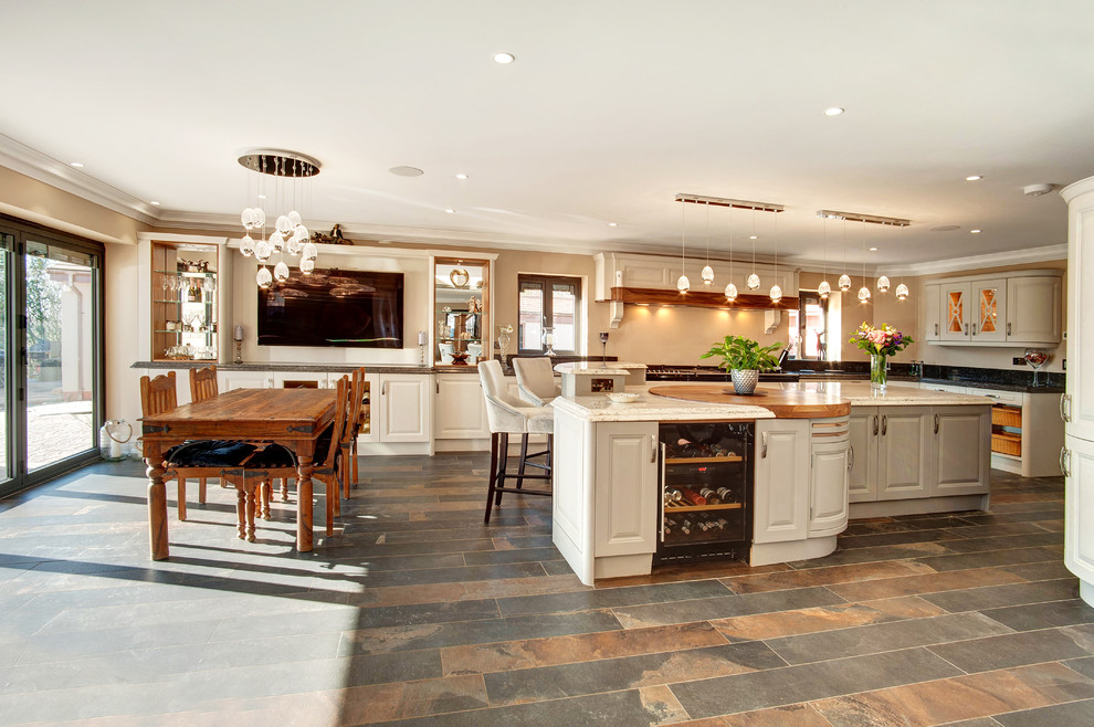 Immagine di una grande cucina classica con lavello integrato, ante con bugna sagomata, top in granito, elettrodomestici neri, pavimento in gres porcellanato, pavimento marrone e top multicolore