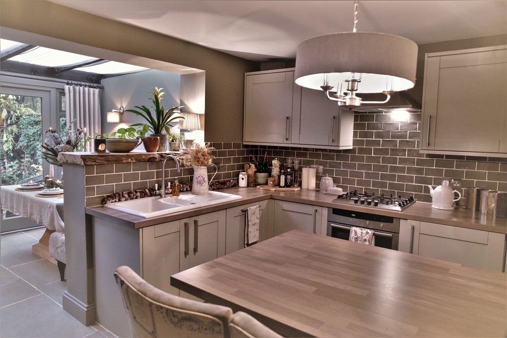 Photo of a medium sized rustic kitchen/diner in Kent with a breakfast bar.