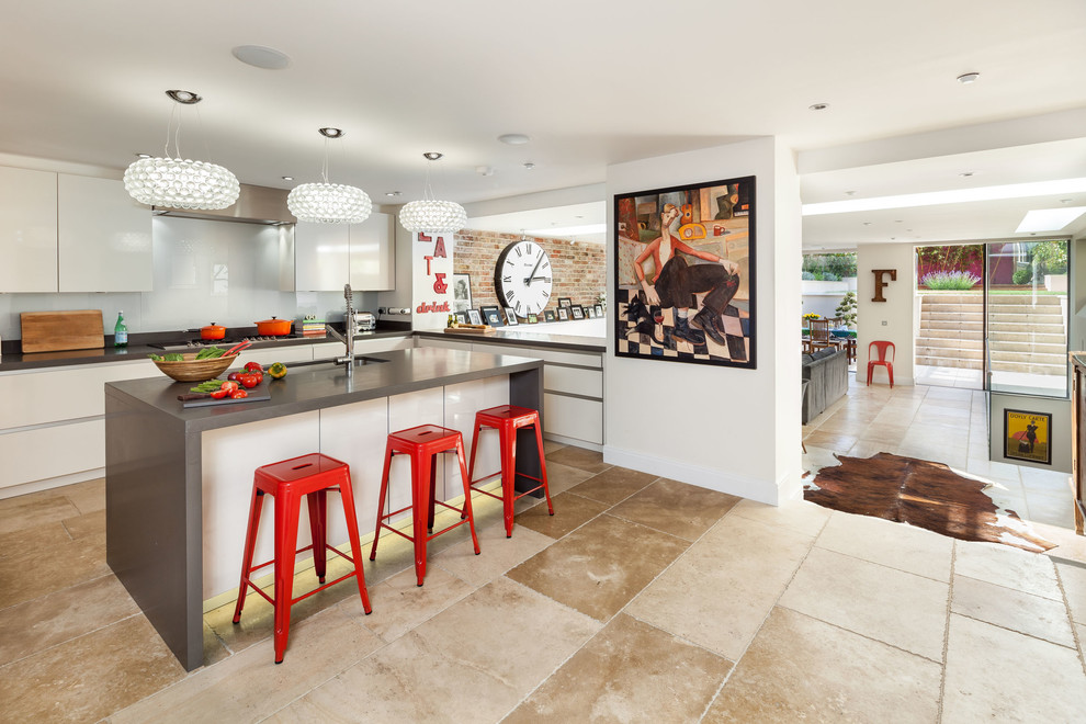 Geschlossene Moderne Küche in L-Form mit Unterbauwaschbecken, flächenbündigen Schrankfronten, weißen Schränken, Küchenrückwand in Weiß, Glasrückwand und Kücheninsel in Oxfordshire