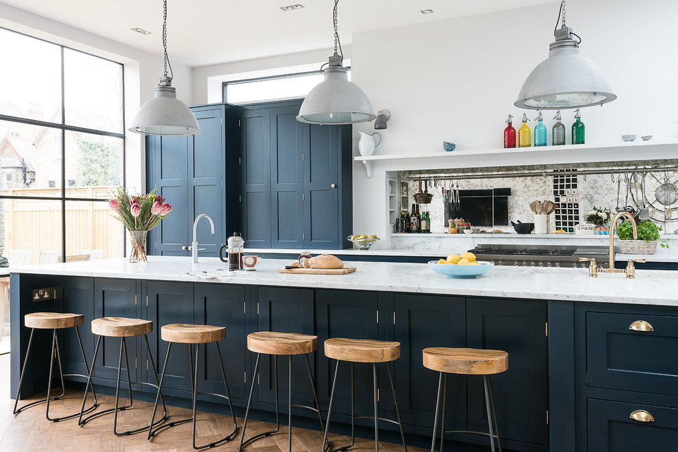 Bild på ett stort vintage kök, med en rustik diskho, skåp i shakerstil, blå skåp, marmorbänkskiva, stänkskydd med metallisk yta, stänkskydd i glaskakel, integrerade vitvaror, mellanmörkt trägolv och en köksö