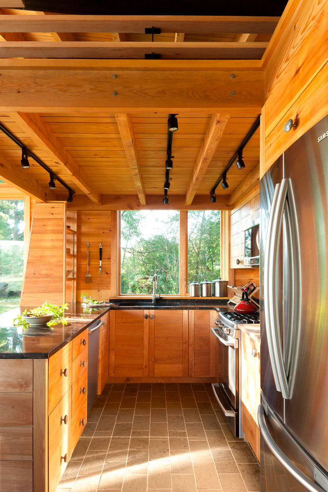 Kleine Urige Küche mit Granit-Arbeitsplatte, Küchengeräten aus Edelstahl, grauem Boden, Unterbauwaschbecken, hellbraunen Holzschränken, Rückwand-Fenster, Halbinsel und Schieferboden in Portland Maine