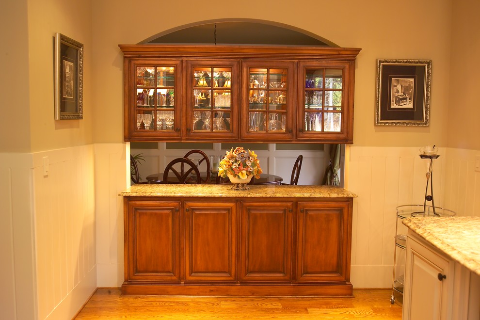 На фото: кухня среднего размера в классическом стиле с обеденным столом, темными деревянными фасадами, гранитной столешницей, паркетным полом среднего тона и островом с