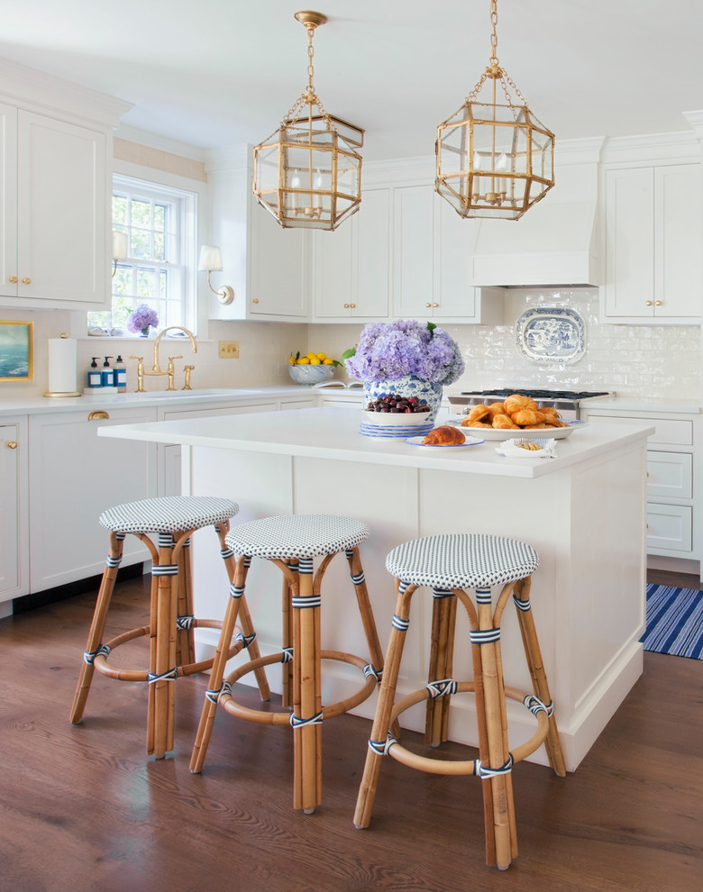 Küche in L-Form mit Schrankfronten im Shaker-Stil, weißen Schränken, Küchenrückwand in Weiß, braunem Holzboden, Kücheninsel und braunem Boden in Boston