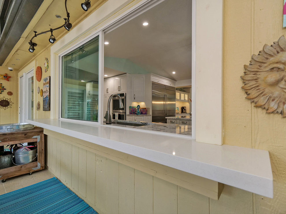 Foto på ett stort tropiskt grå kök med öppen planlösning, med skåp i shakerstil, vita skåp, bänkskiva i kvarts, vitt stänkskydd, stänkskydd i keramik, rostfria vitvaror, vinylgolv och flera köksöar