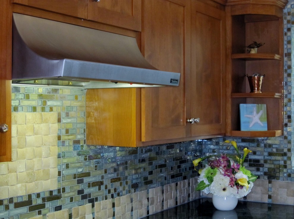 Kitchen - tropical kitchen idea in Los Angeles with glass sheet backsplash and stainless steel appliances