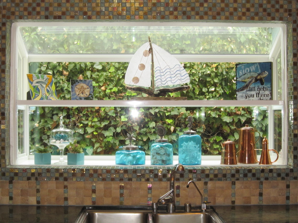 На фото: кухня в морском стиле с фартуком из стекла и техникой из нержавеющей стали