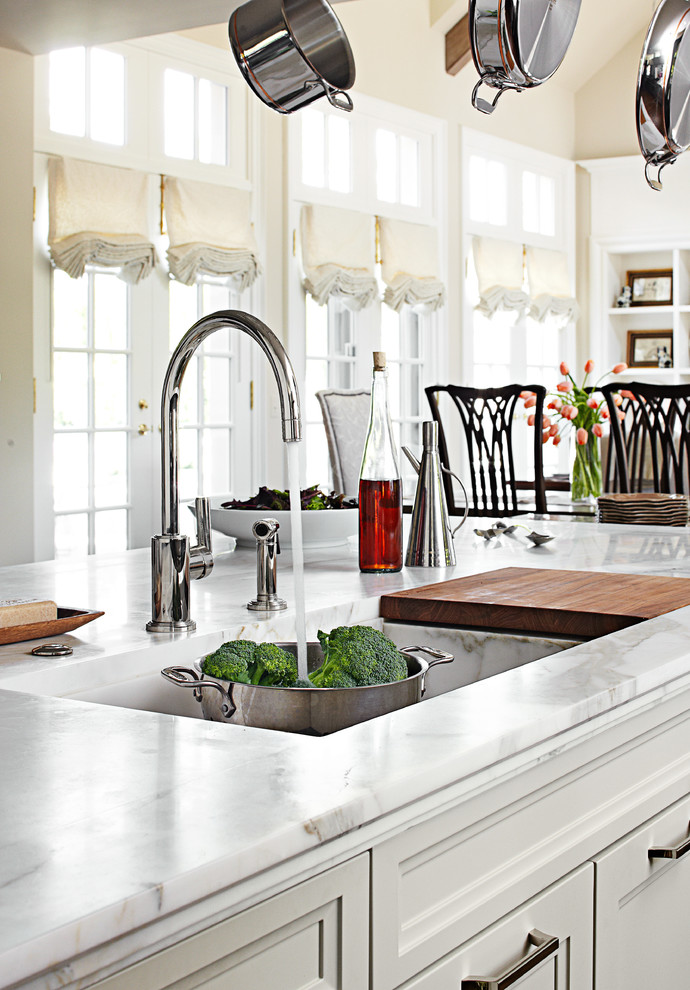 Idee per una cucina minimal di medie dimensioni con lavello sottopiano, ante con riquadro incassato, ante bianche, top in marmo e elettrodomestici in acciaio inossidabile