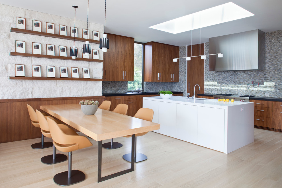 На фото: угловая кухня-гостиная в современном стиле с плоскими фасадами, темными деревянными фасадами, серым фартуком, фартуком из плитки мозаики, светлым паркетным полом и островом с
