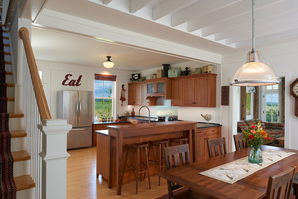 ワシントンD.C.にあるカントリー風のおしゃれなキッチン (シェーカースタイル扉のキャビネット、中間色木目調キャビネット、シルバーの調理設備、淡色無垢フローリング、白いキッチンパネル) の写真