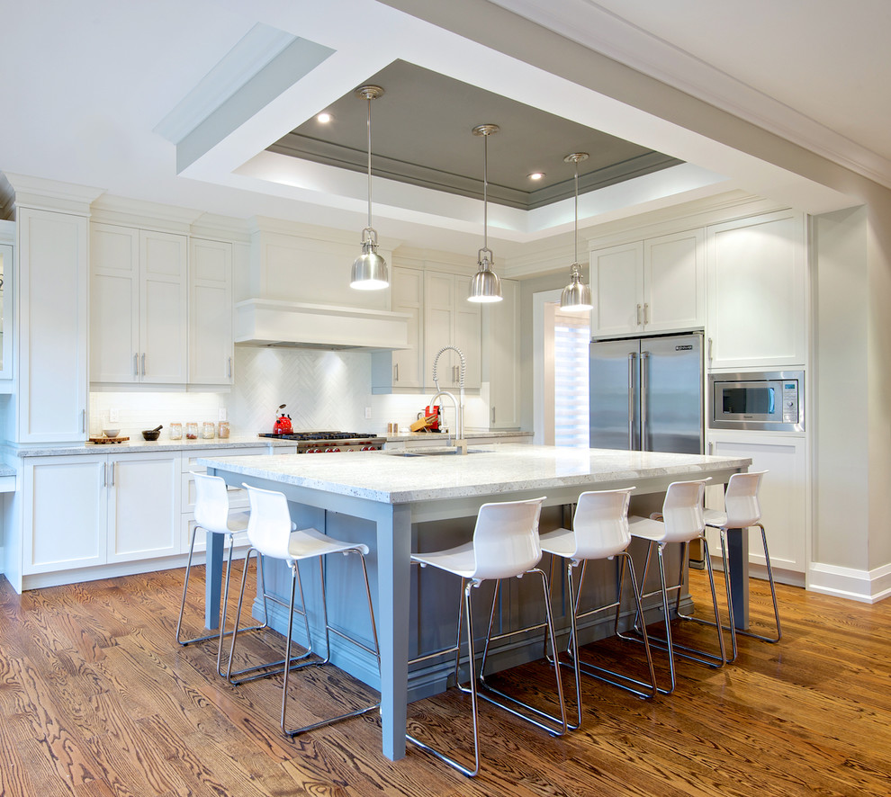 Example of a mid-sized trendy l-shaped medium tone wood floor open concept kitchen design in Toronto with a double-bowl sink, shaker cabinets, white cabinets, granite countertops, white backsplash, porcelain backsplash, stainless steel appliances and an island