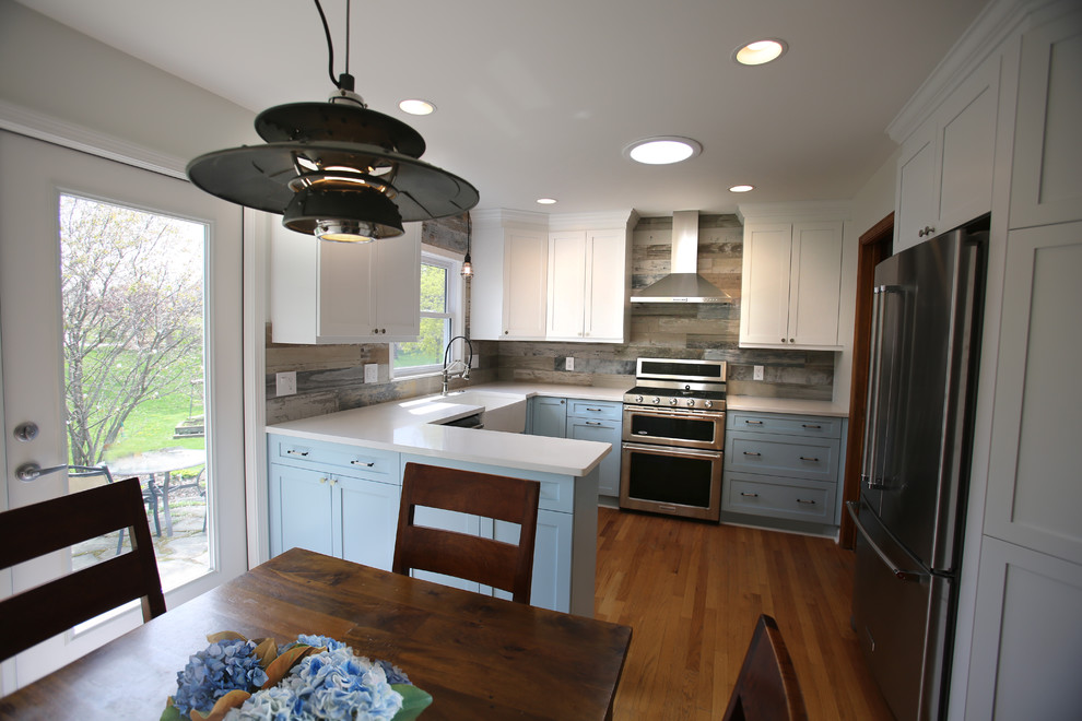 Small cottage u-shaped medium tone wood floor and brown floor eat-in kitchen photo in Detroit with a farmhouse sink, shaker cabinets, blue cabinets, quartz countertops, gray backsplash, ceramic backsplash, stainless steel appliances and white countertops
