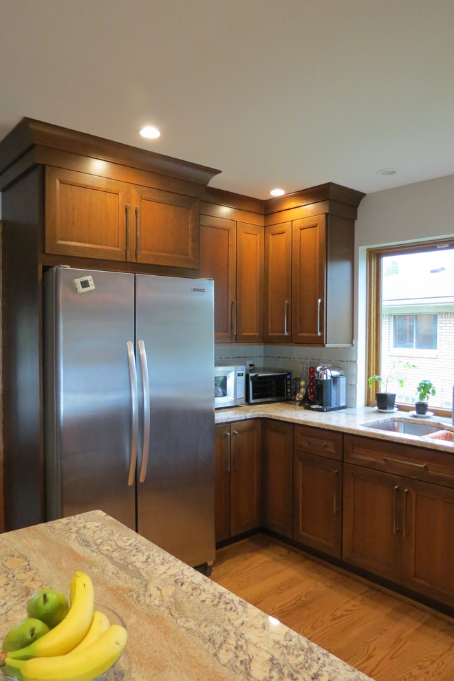 Exempel på ett mellanstort klassiskt kök, med en undermonterad diskho, släta luckor, skåp i mellenmörkt trä, granitbänkskiva, vitt stänkskydd, stänkskydd i glaskakel, rostfria vitvaror, mellanmörkt trägolv, en halv köksö och brunt golv
