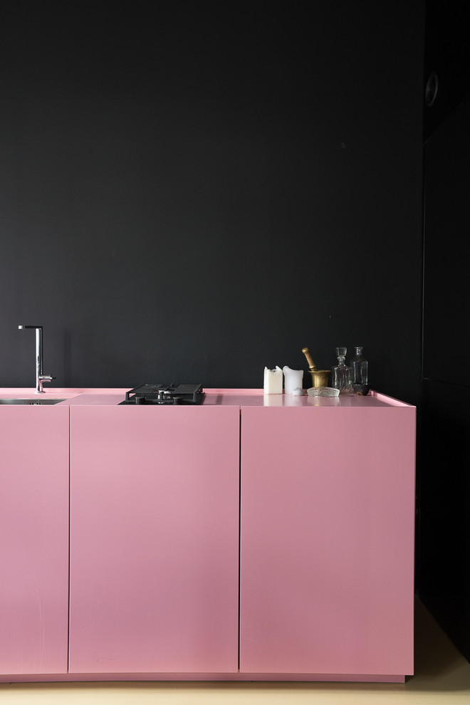 Immagine di una cucina lineare nordica chiusa e di medie dimensioni con lavello integrato, ante lisce, ante rosse, pavimento in cemento, nessuna isola e pavimento beige