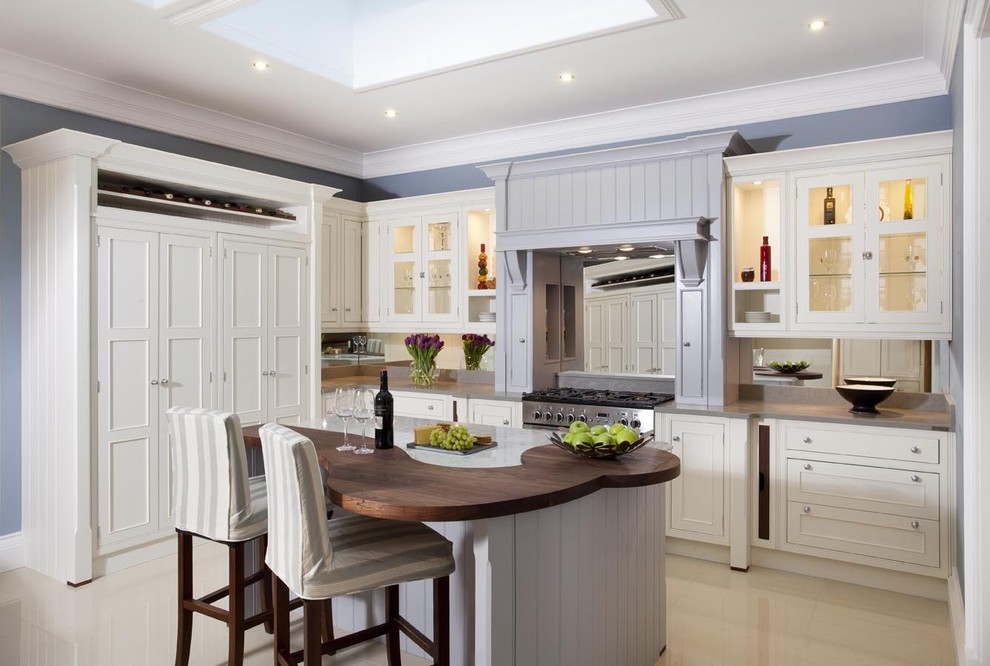 Diseño de cocinas en L tradicional con armarios estilo shaker, puertas de armario blancas y electrodomésticos de acero inoxidable