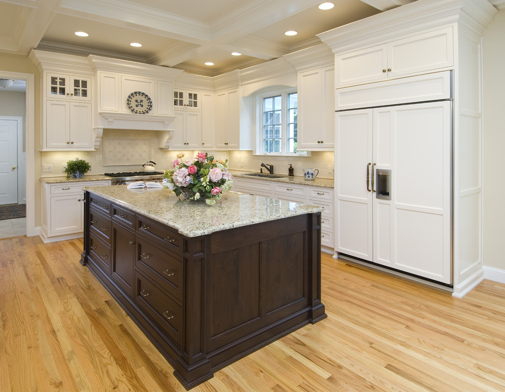 Inspiration for a timeless l-shaped eat-in kitchen remodel in New York with granite countertops, paneled appliances, an undermount sink, beaded inset cabinets, white cabinets, beige backsplash and stone tile backsplash
