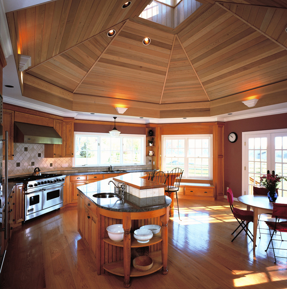 Immagine di una cucina abitabile chic con lavello sottopiano, ante in legno scuro, elettrodomestici in acciaio inossidabile, pavimento in legno massello medio e paraspruzzi beige